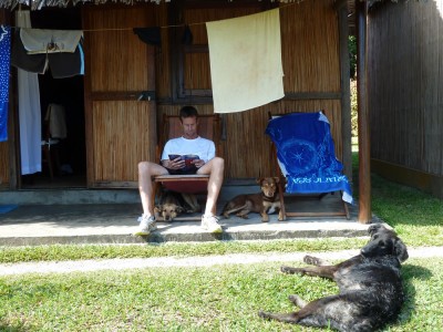Pierre in front of our cabin with Tina (under the chair), Chocolat, and Otis (in front).